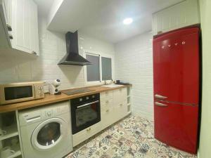 萨拉戈萨Acogedor apartamento a 5 min del Ave的一间带红色门和洗衣机的厨房