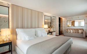 波尔图Wine & Books Porto Hotel的卧室配有一张白色的大床和一张沙发。