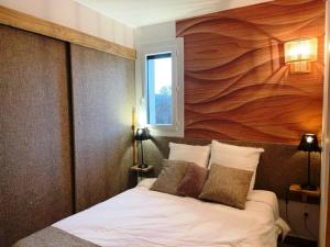 昂塞勒Le Logis de Bamby的一间卧室配有一张带大型木墙的床。
