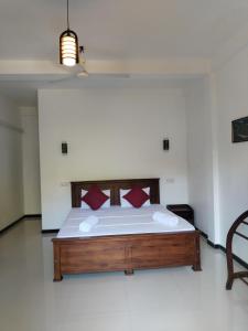 坦加拉Leen Tangalle的一间卧室配有一张带红色枕头的大床