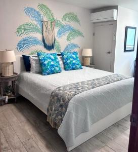 圣胡安KASA Brisa Marina - 1 bed 1 bath for 2 OCEAN VIEW BALCONY BEACHFRONT CONDO POOL的一间卧室配有一张带蓝色枕头的大床