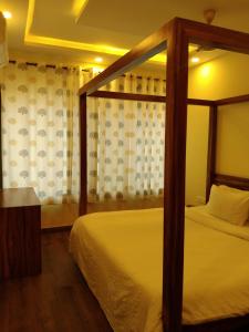 尼禄Luxury 2BHK Apartment Near Candolim的一间卧室设有天蓬床和窗户。
