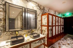 波尔图Wine & Books Porto Hotel的一间带两个水槽和大理石墙的浴室