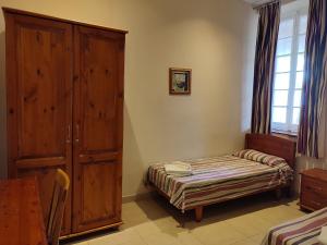 彭布罗克SC Club Village的一间卧室配有一张床和一个木制橱柜