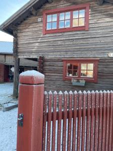 莫拉Stallet - Hemma hos Mait的前面有红墙的木屋