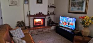 斯蒂亚Casa Lichio的一间带电视和壁炉的客厅