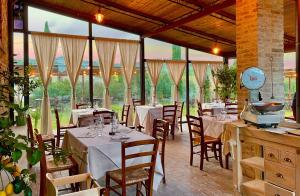 瓜尔迪斯塔洛Locanda Le Giunche的餐厅设有白色的桌椅和窗户。
