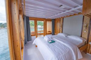 纳闽巴霍Phinisi Boat Maheswari Komodo的一间卧室配有一张床,上面有托盘