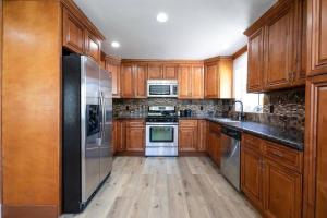 洛杉矶Beautiful Spacious Home的厨房配有木制橱柜和不锈钢用具