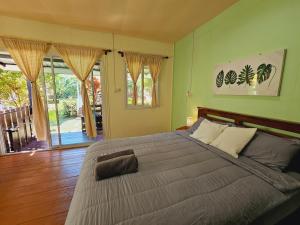 象岛Baan suan khun ta บ้านพักสวนคุณตา的一间卧室设有一张带绿色墙壁的大床
