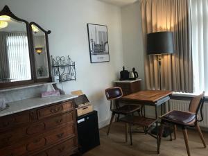 鹿特丹Bed and Breakfast Rotterdam的客房设有书桌和桌椅。