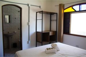 卡拉瓜塔图巴Pousada Yurgs的一间卧室配有一张床,浴室设有淋浴。