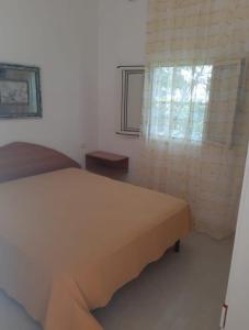 圣尼科拉Perla Marina的一间卧室设有一张床和一个窗口