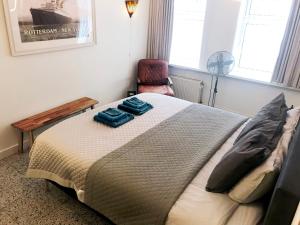 鹿特丹Bed and Breakfast Rotterdam的一间卧室配有一张大床和一把椅子