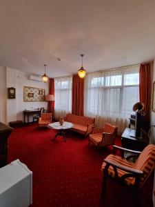 卡库拉塔Hotel Perla Oltului的客厅配有椅子和桌子。