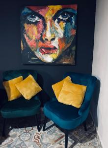 戈雷尼斯卡地区采尔克列Rooms & Apartment ZALA Airport shuttle option的两张蓝色的椅子和一幅女人的画