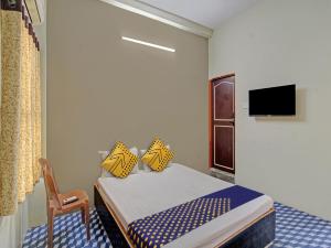 SakardarāOYO Hotel G.K Lodging and Guest House的一间小卧室,配有一张床和一把椅子