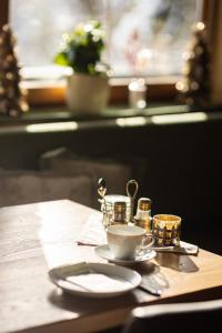 拉姆绍达赫斯坦Pension Dachsteinhof的一张桌子,上面有盘子和咖啡杯