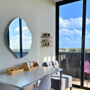 科苏梅尔Brand new condo with Rooftop pool的一间带桌子和镜子的用餐室