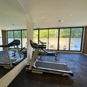 科苏梅尔Brand new condo with Rooftop pool的健身房设有两台跑步机和大窗户