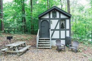 赛维尔维尔Tiny Home Cottage Near the Smokies #1 Olga的黑白的棚子,两把椅子和一张野餐桌