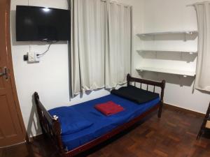 Telêmaco BorbaHotel Dalcol Economic的卧室配有蓝色的床,墙上配有电视