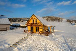 泰里克兹Domek Tylicz Widoki的雪中的一个黄色小房子