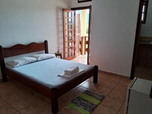 乌巴图巴Pousada Sol da Lagoinha的一间卧室配有带毛巾的床
