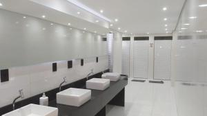 Telêmaco BorbaHotel Dalcol Economic的白色浴室设有4个水槽和摊位