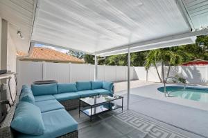 萨拉索塔Ultimate Private Home with Heated Pool的一个带蓝色沙发和游泳池的庭院