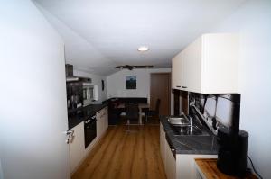 费尔兹姆斯Haus Jakob的厨房铺有木地板,配有白色橱柜。