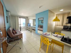 纳塔尔Ponta Negra Flats Confort ACCOMMODATIONS AMAQ 18 andar的厨房以及带桌椅的起居室。