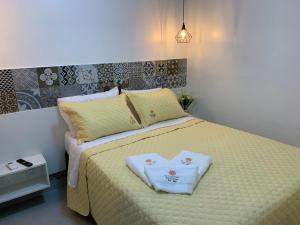 塔曼达雷FLAT ECO RESORT PRAIA DOS CARNEIROS的一间卧室配有一张带心形毛巾的床