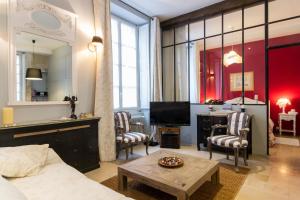 第戎卢瓦西酒店的客厅配有沙发、椅子和电视