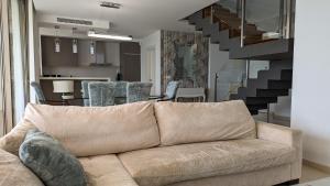 比利亚霍约萨PARADISE beachfront luxury villa的带沙发和楼梯的客厅