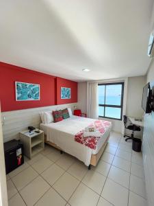 纳塔尔Ponta Negra Flats Confort ACCOMMODATIONS AMAQ 18 andar的一间卧室设有一张床和红色的墙壁