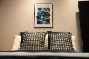 贝尔法斯特Harland House的一张带两个枕头的床和一张墙上的照片