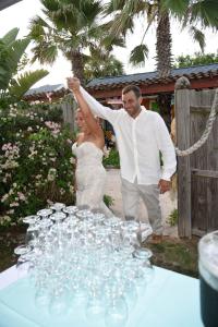 弗拉格勒海滩SI COMO NO INN的站在桌子旁的一位新娘和新郎,拿着酒杯