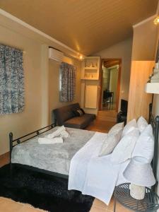 里奥Βίλα Σια的一间卧室配有一张带白色床单和一张沙发的床。
