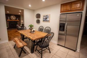 埃伦斯堡The Charming Cowboy House的厨房配有木桌和冰箱。
