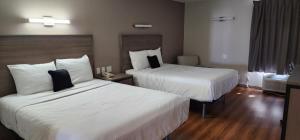 Pontoon BeachRed Lion Inn & Suites Pontoon Beach的酒店客房,配有两张带白色床单的床