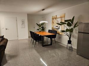 AlfterCharmante und stilvolle Wohnung的用餐室配有木桌和黑椅子