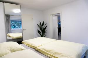AlfterCharmante und stilvolle Wohnung的一间卧室配有两张床和镜子