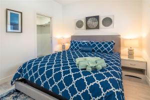 Upper LandCayman Luxury Rentals at The Grove的一间卧室配有蓝色和白色的床以及两盏灯。