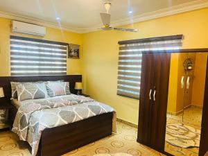AshalebotweAJ Homes的一间卧室配有一张床、一个窗户和一个衣柜