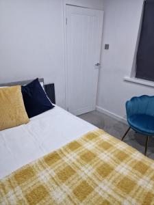 Sheriff HillCosy and Unique Bedroom In Gateshead的一间卧室配有一张床和一张蓝色椅子