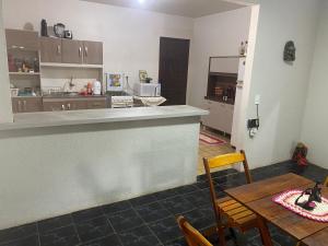 伊瓜苏Espaço confortável no centro da cidade的厨房以及带桌子和柜台的用餐室。