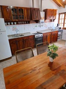 瓜伊马延La Primi的厨房配有木桌、椅子和冰箱