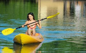 萨武萨武克罗阳光雨林Spa度假酒店的水中划皮艇的年轻女孩