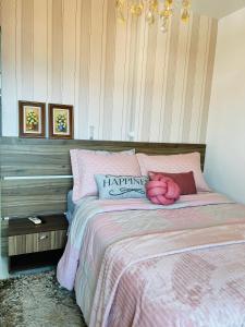 伊达贾伊Apto 2 quartos, completo e aconchegante的一间卧室,床上有粉红色的动物